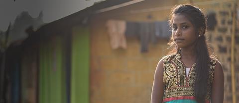 A girl stands in a village